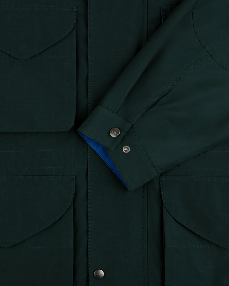 Lightweight Barn Jacket in dark green, close-up of pocket flaps, snap buttons, and overlapping sleeve.