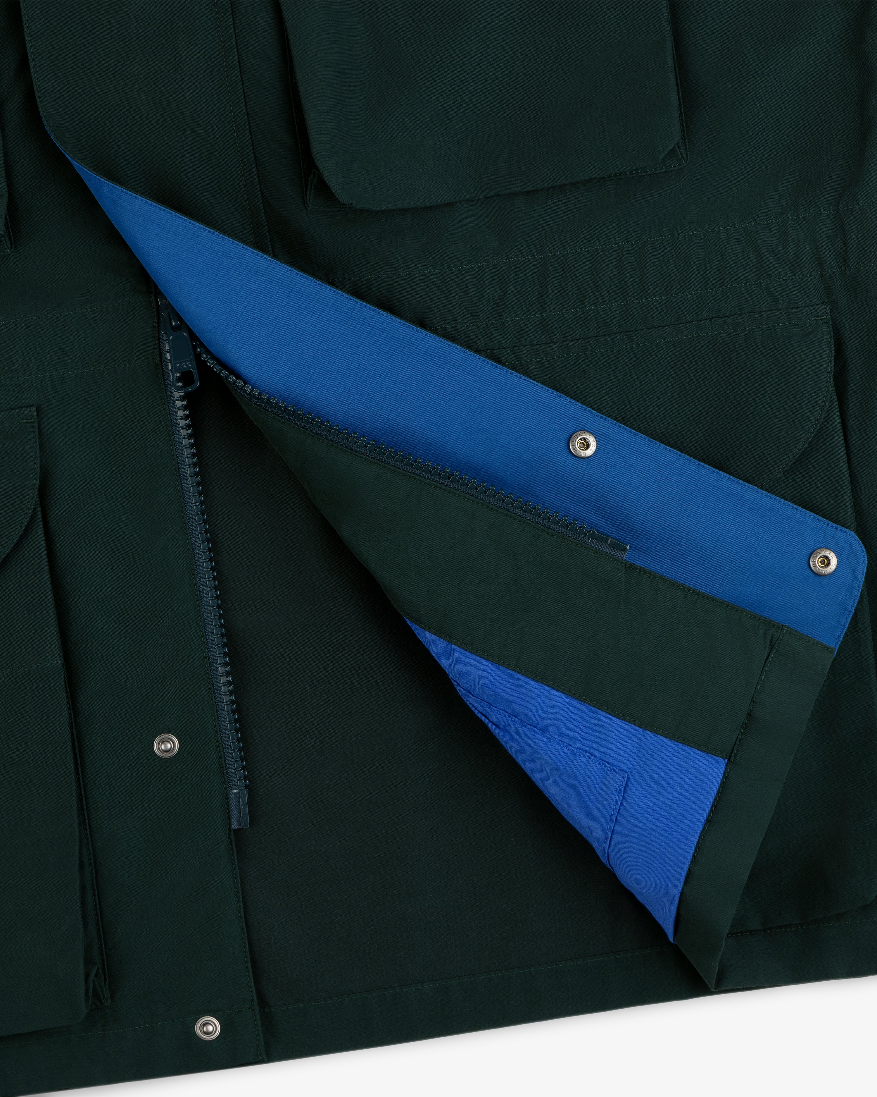 Lightweight Barn Jacket in dark green with a partially unzipped flap, revealing a bright blue lining.