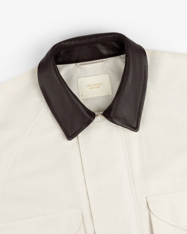 Lightweight Barn Jacket in cream with black leather collar and two front pockets, laid flat showing the label.