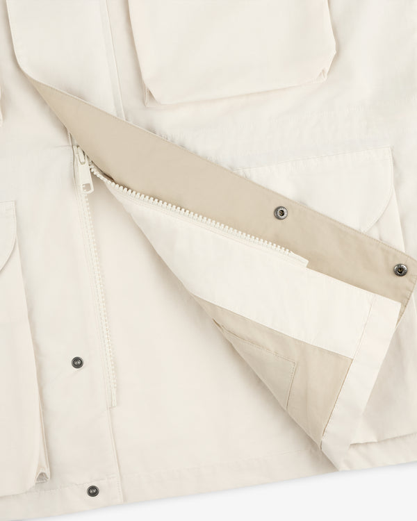 Close-up of the Lightweight Barn Jacket in beige with a partially unzipped front, snap-button flap, and pockets.