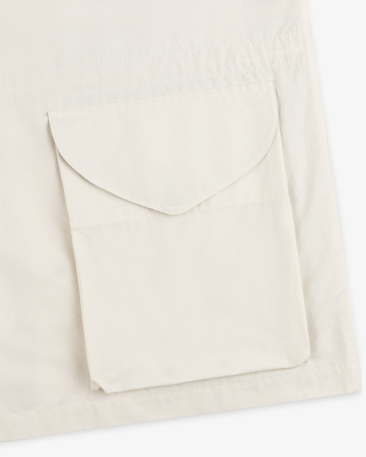 A close-up of the Lightweight Barn Jacket in cream, featuring a large, flap pocket on the fabric.