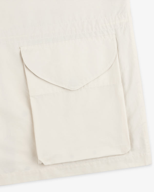 A close-up of the Lightweight Barn Jacket in cream, featuring a large, flap pocket on the fabric.