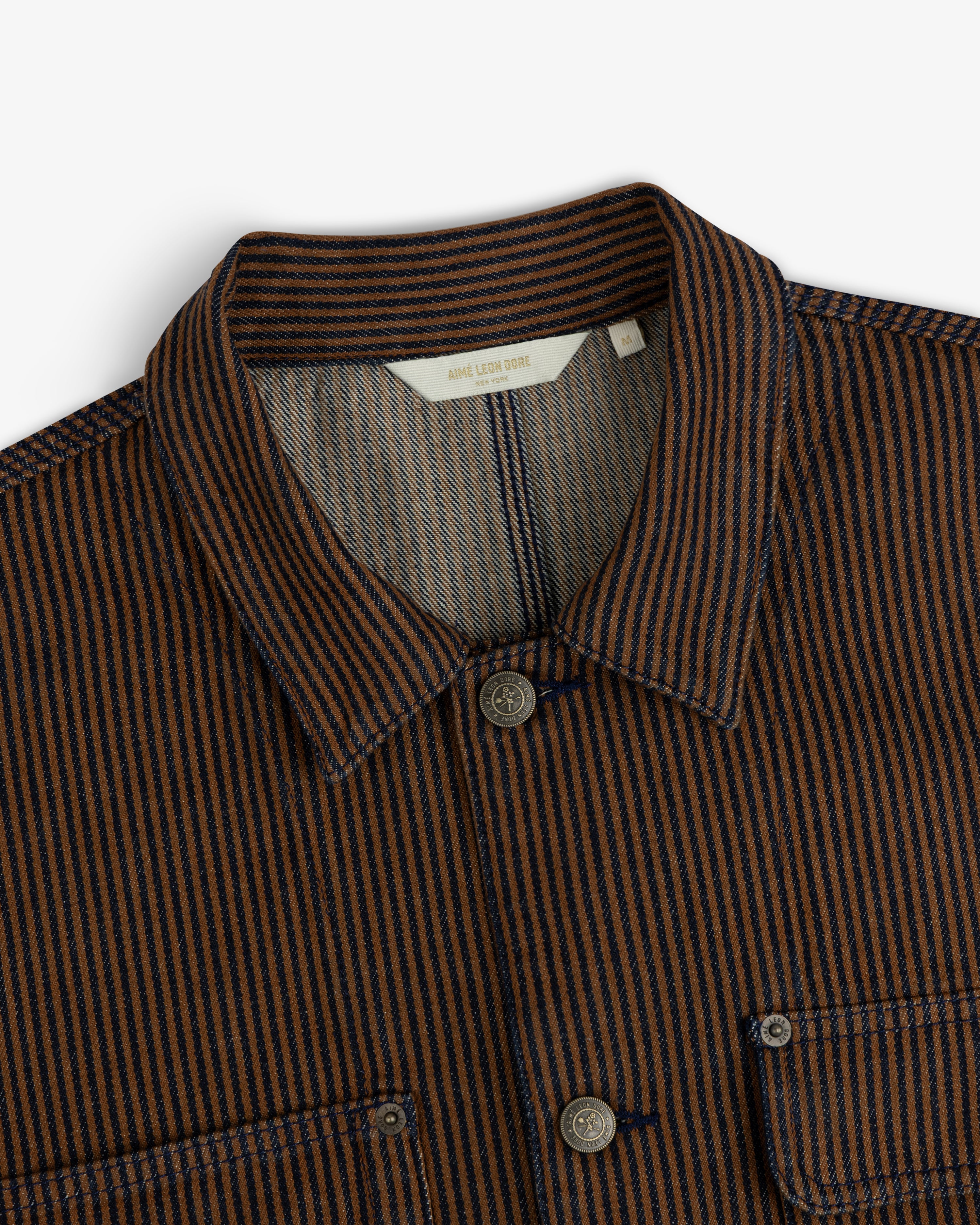 Hickory Stripe Denim Trucker Jacket in brown and navy stripes, collared with buttons and chest pockets, shoulder-up view.