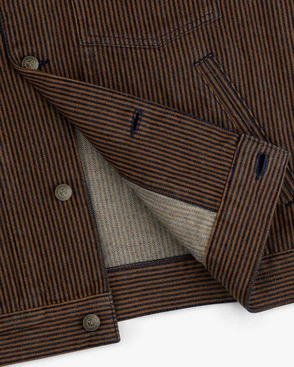 Close-up of the Hickory Stripe Denim Trucker Jacket, featuring brown and navy stripes, buttons, and inner lining.