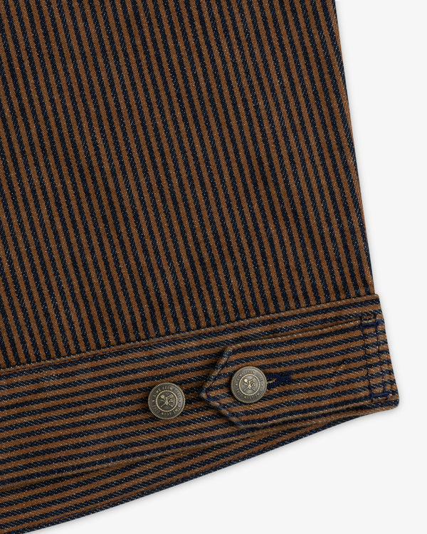 Close-up of the Hickory Stripe Denim Trucker Jacket: brown/navy stripes, stitched edge, and two metal buttons.