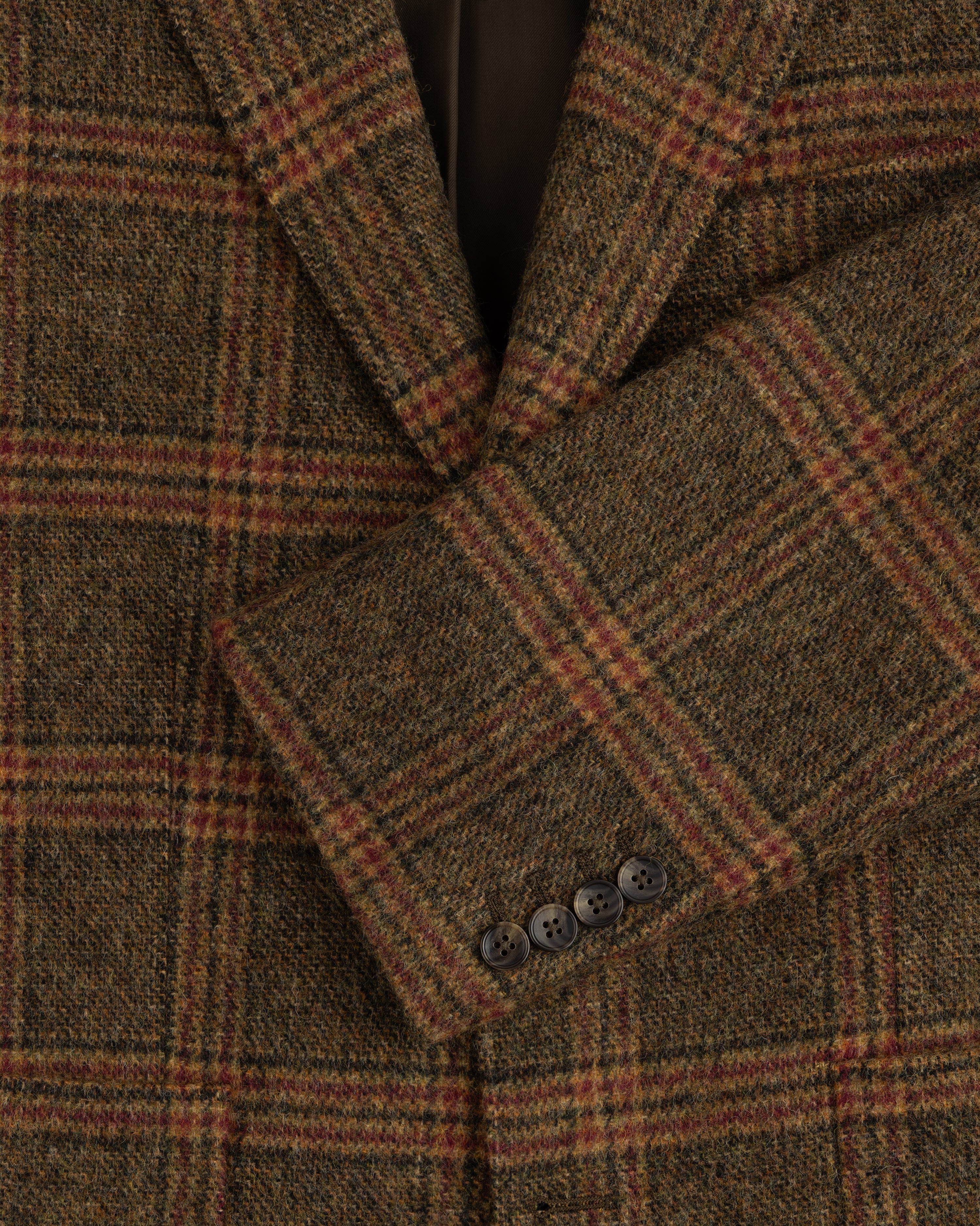 Close-up of a brown Single-Breasted Plaid Tweed Suit Jacket with four buttons on the sleeve cuff.