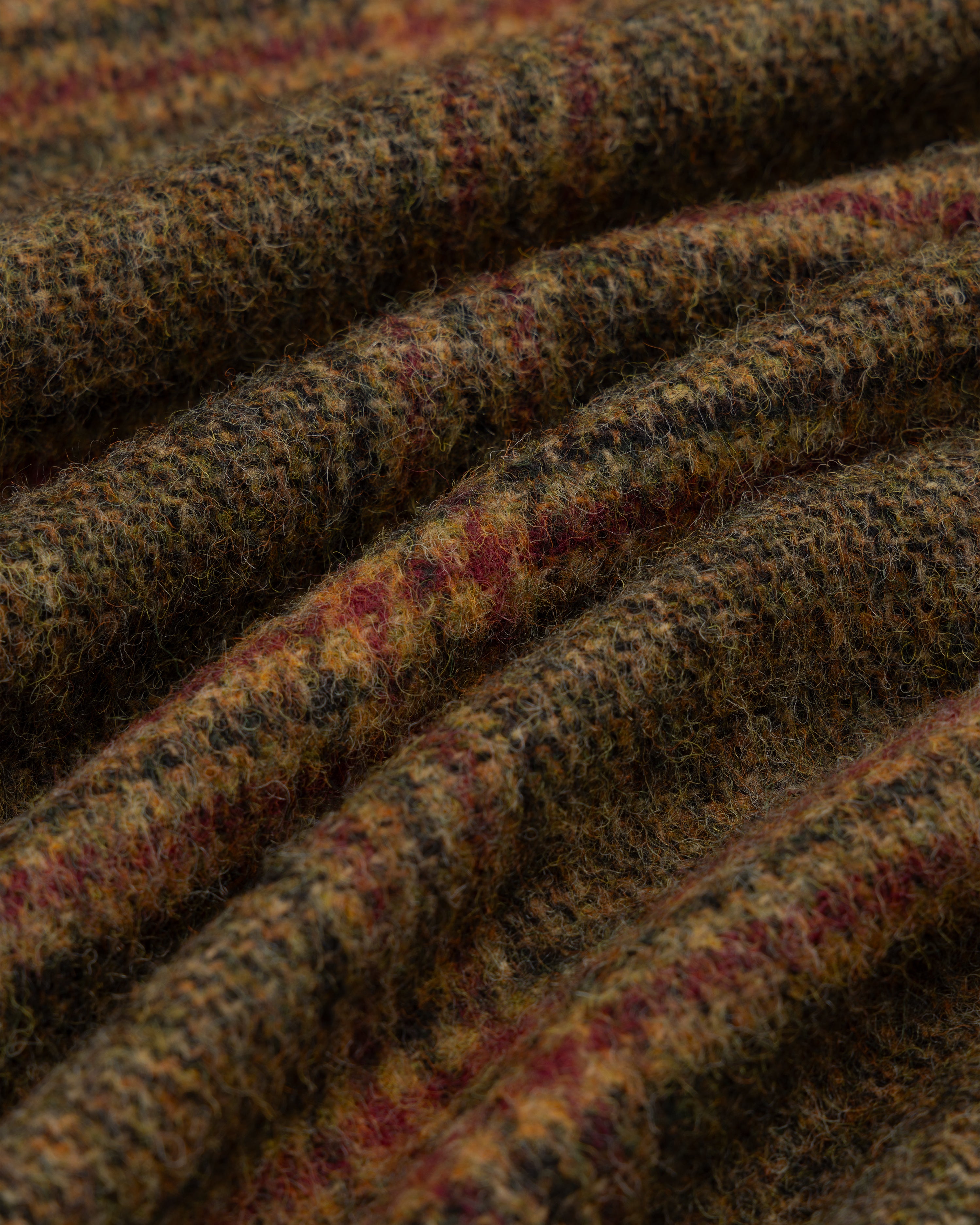 Close-up of a Single-Breasted Plaid Tweed Suit Jacket featuring a brown, green, and red textured plaid pattern.