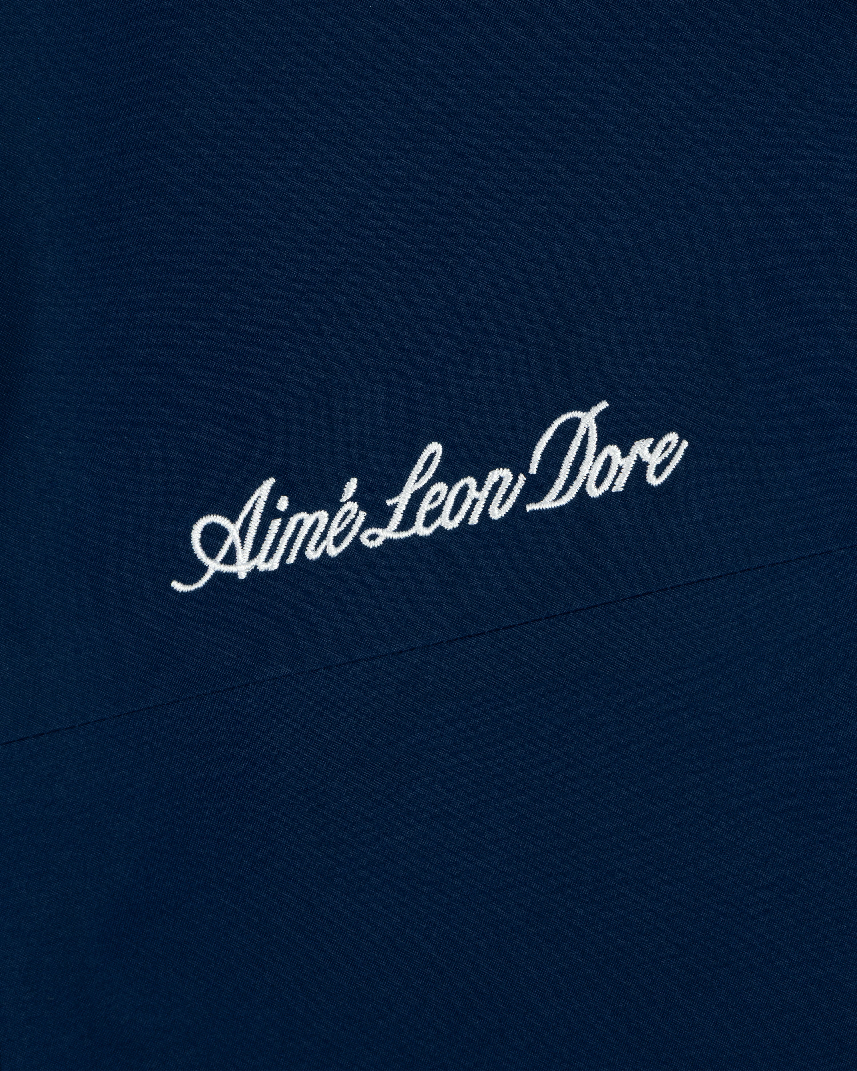 Yankees GORE-TEX Rain Delay Jacket features Aimé Leon Dore in white script on dark blue fabric.