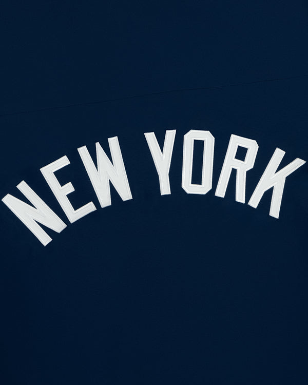 White NEW YORK text in caps on dark blue, featured on the Yankees GORE-TEX Rain Delay Jacket.