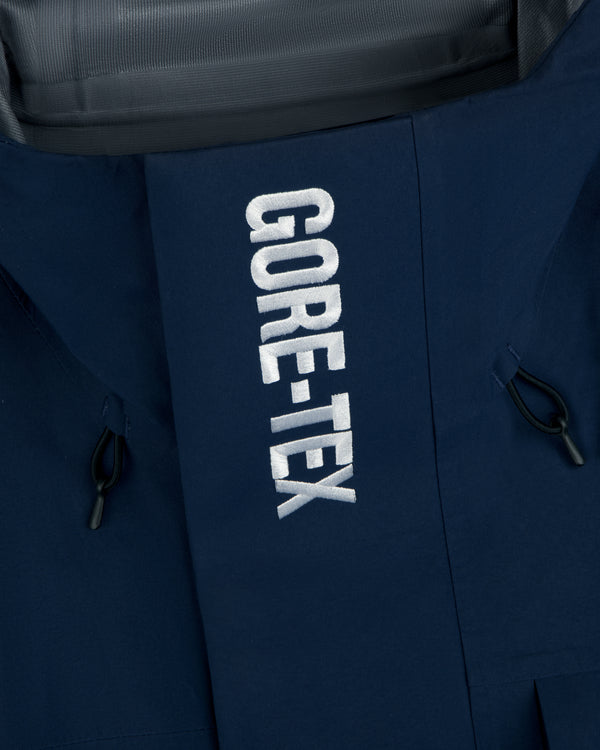 Close-up of Yankees GORE-TEX Rain Delay Jacket, blue with white GORE-TEX embroidery and black side drawstrings.