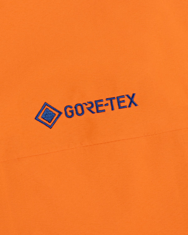 Mets GORE-TEX Rain Delay Jacket: Orange fabric, blue embroidered logo, square design on upper left.