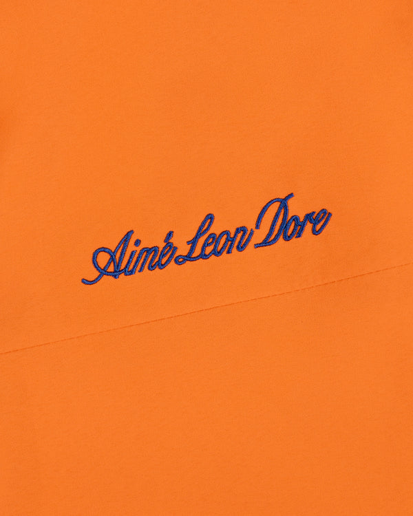 Mets GORE-TEX Rain Delay Jacket in orange with Aimé Leon Dore embroidered in blue script.