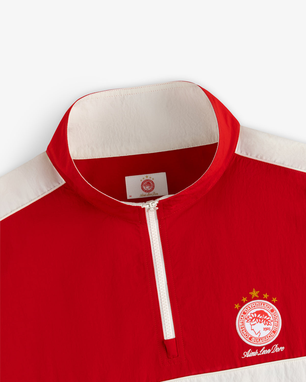 ALD / Olympiacos F.C. Nylon Quarter Zip Pullover in red and white with a sports crest on the chest.