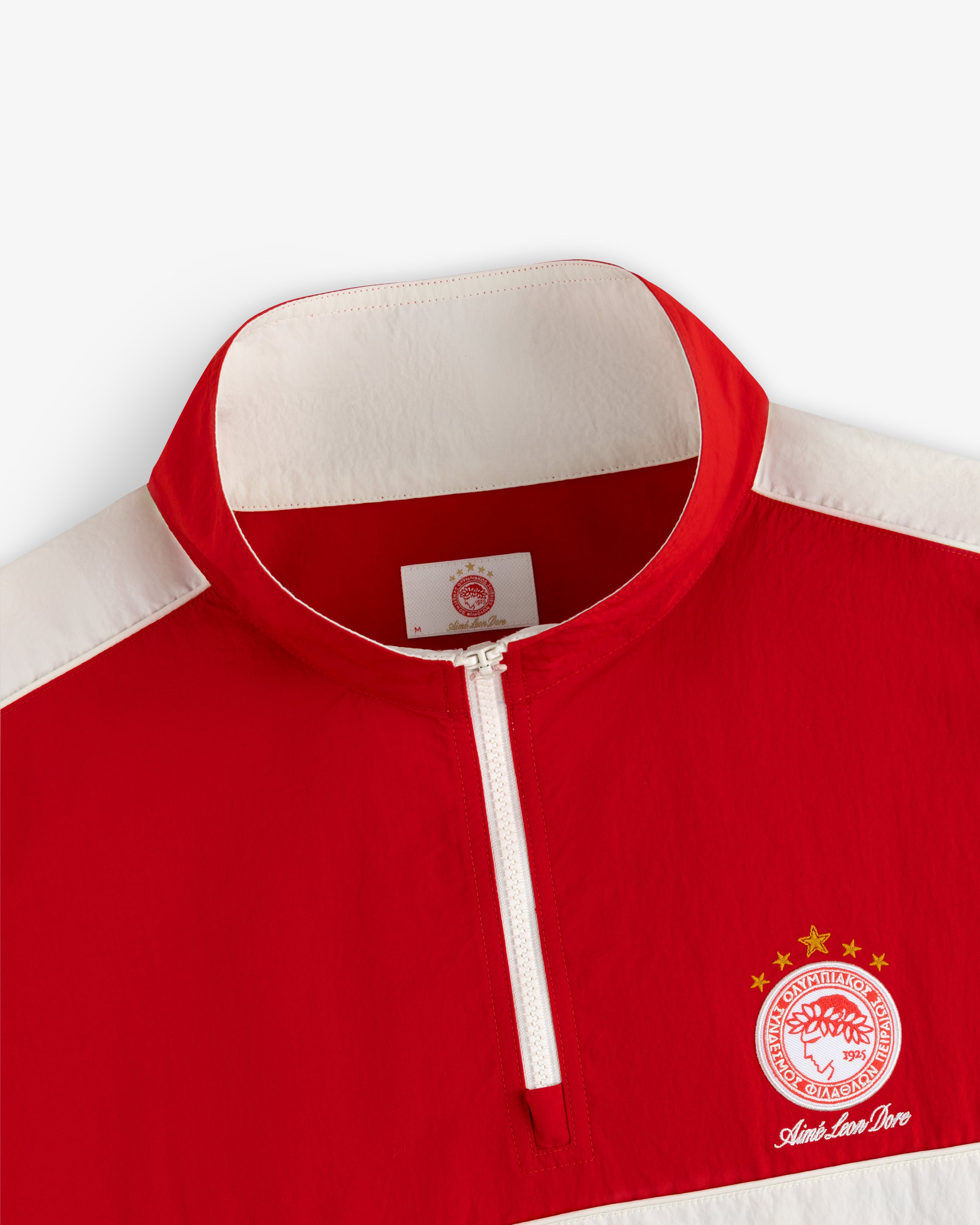 ALD / Olympiacos F.C. Nylon Quarter Zip Pullover in red and white with a sports crest on the chest.
