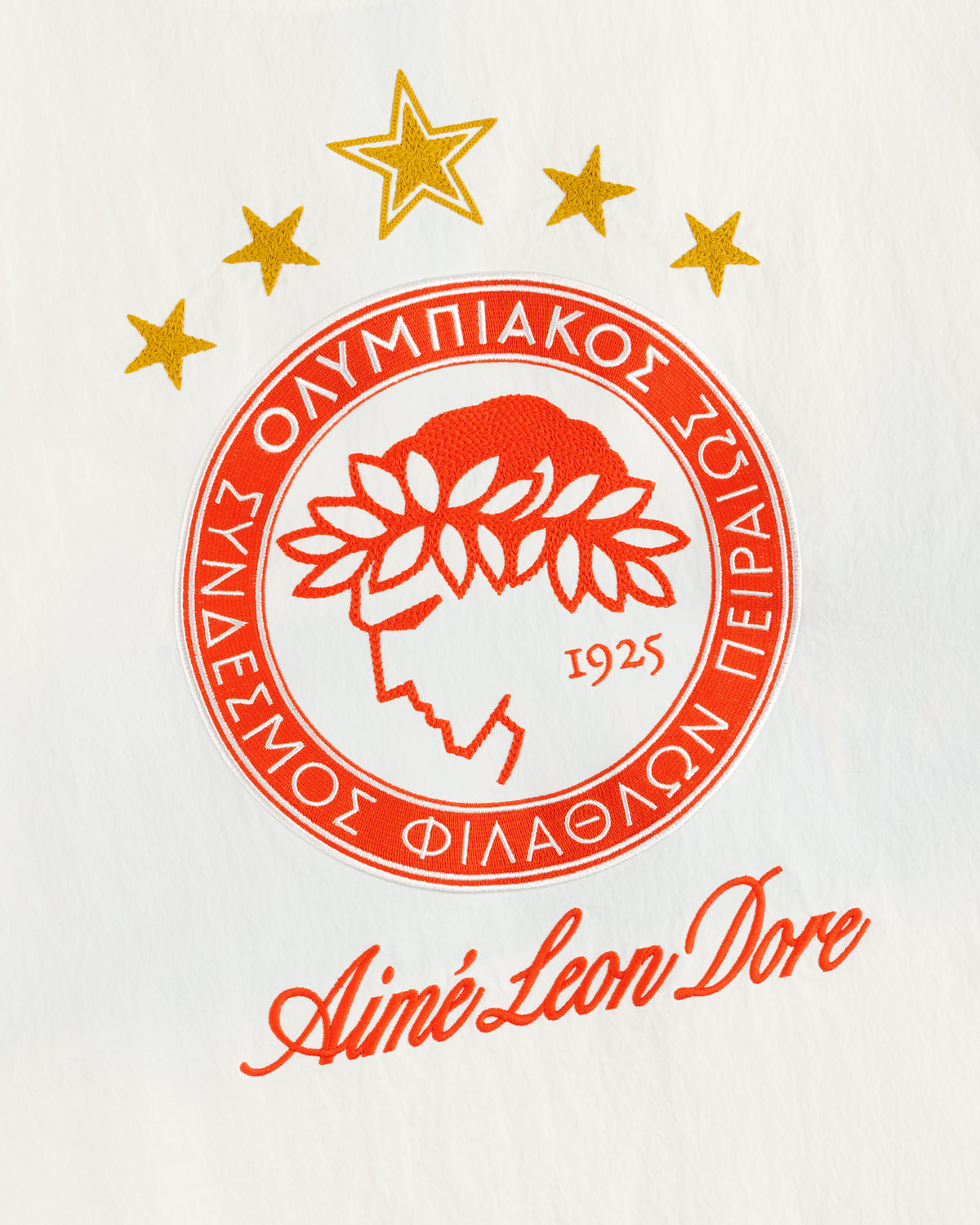 ALD / Olympiacos F.C. Nylon Quarter Zip Pullover featuring a circular logo with five gold stars and Aimé Leon Dore text.