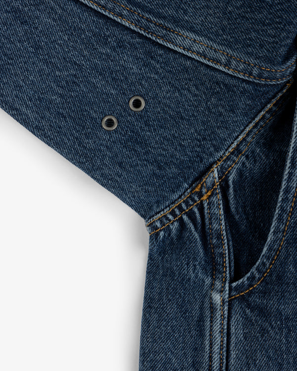 Close-up of the Denim Chore Coat underarm with two metal ventilation eyelets and orange stitching.
