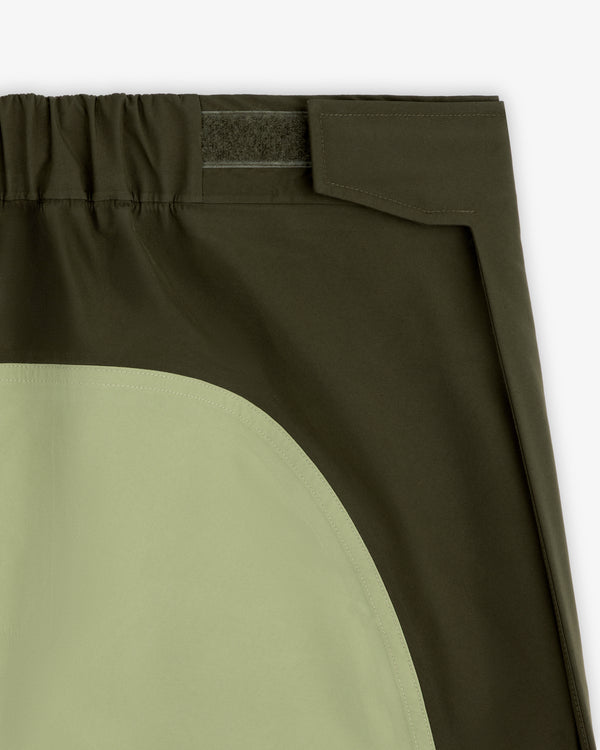 Close-up of ALD/The North Face GORE-TEX Pant featuring olive patch, elastic waist, and hook-and-loop fastener.