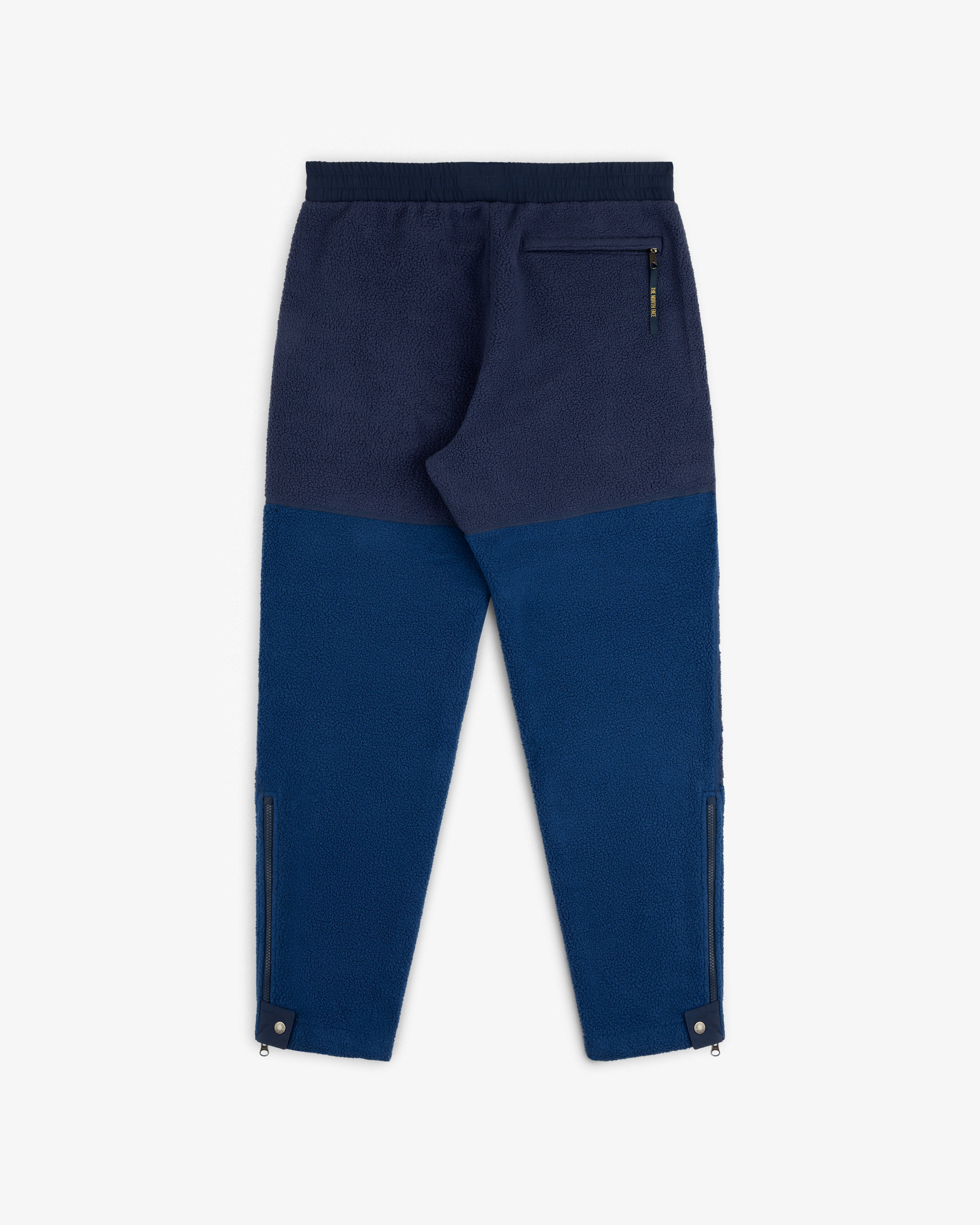 ALD / The North Face Denali Fleece Pant in blue, elastic waist, back zip pocket, ankle zips, shown flat on white.