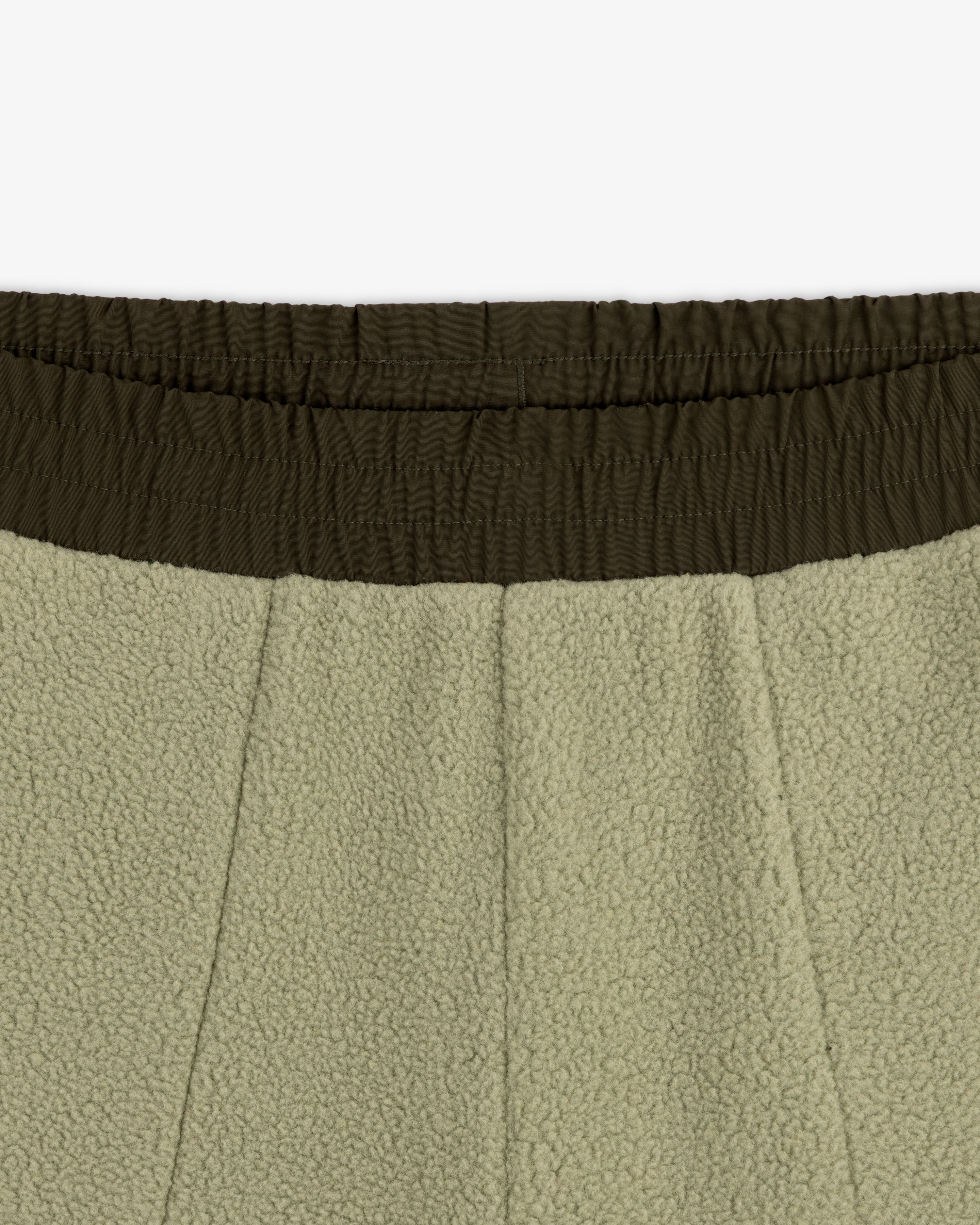 Close-up of ALD / The North Face Denali Fleece Pant with olive green elastic waistband and seam details.