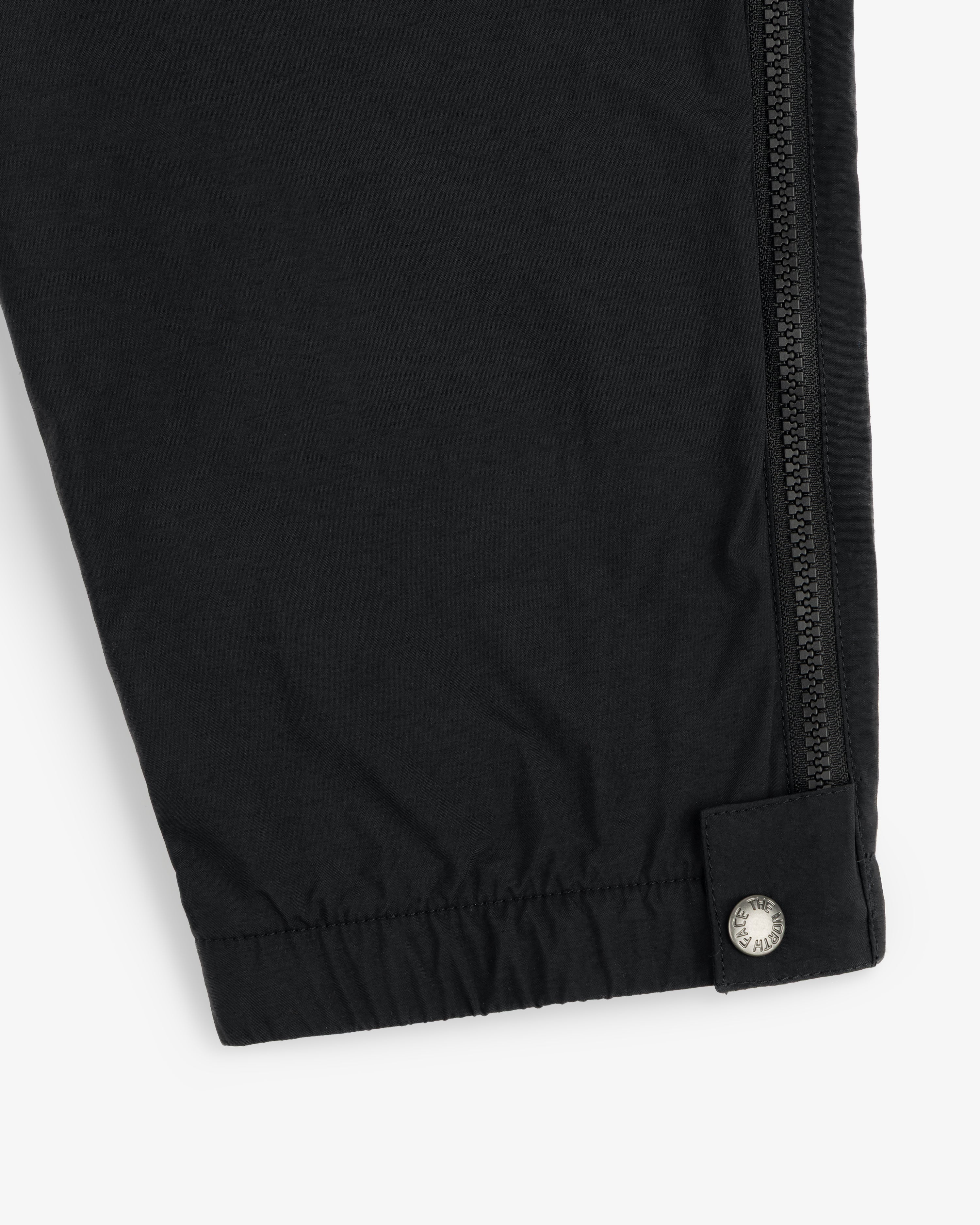ALD / The North Face Nylon Denali Pant features a black leg with a zipper seam and silver snap by the elastic cuff.