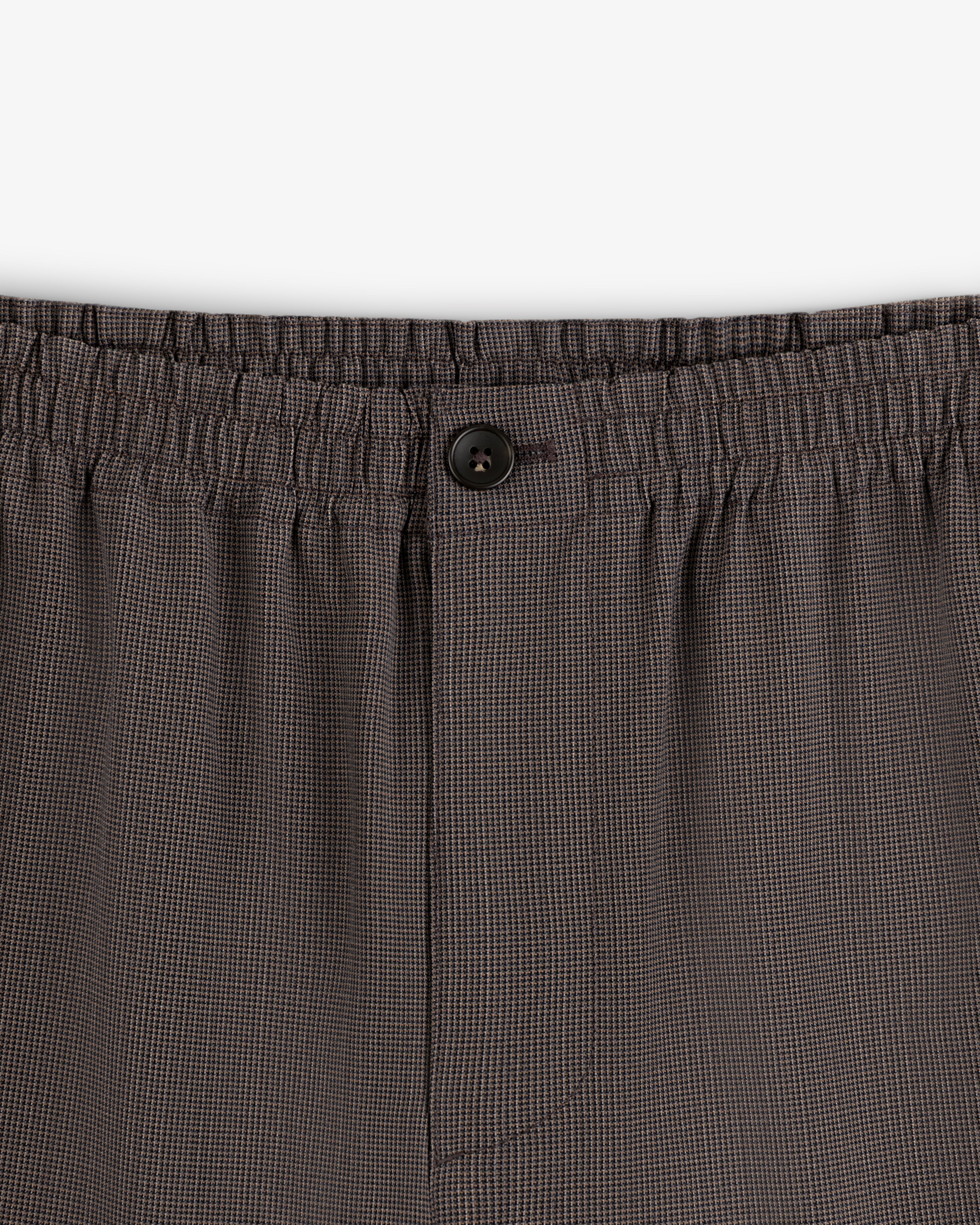 Close-up of Houndstooth Elasticated Waist Trouser featuring button and fly details.