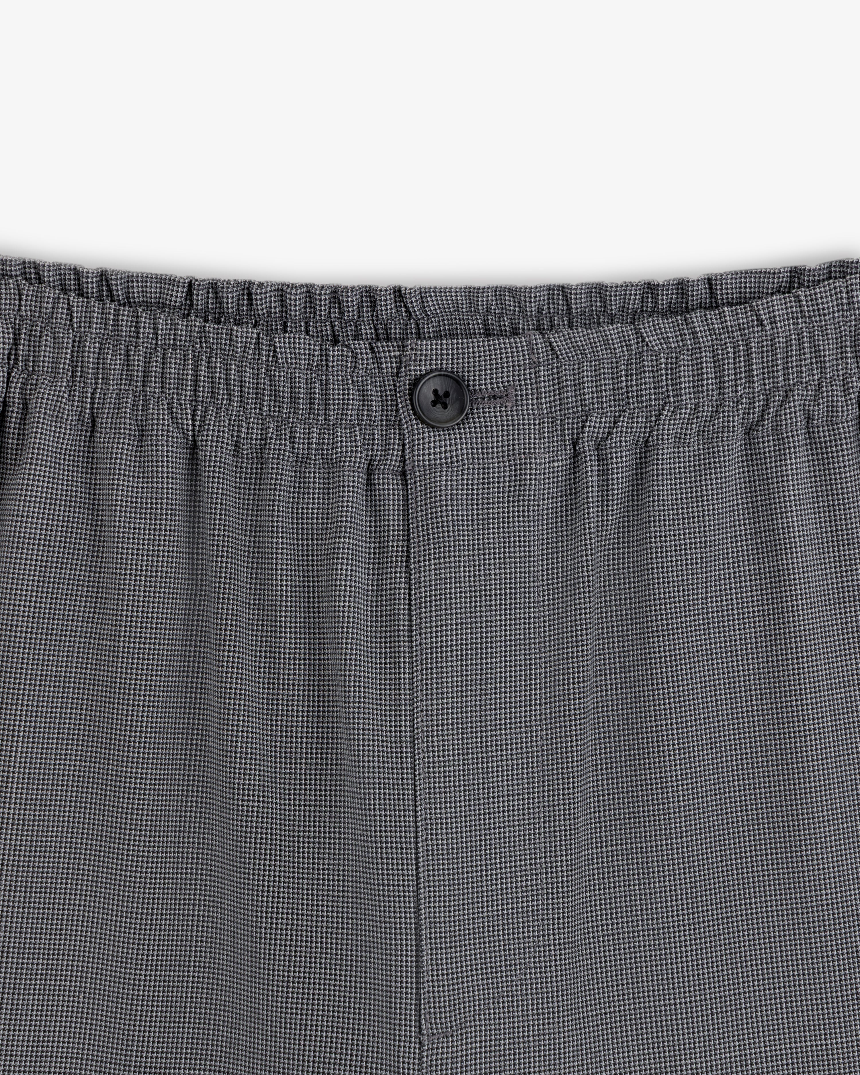 Close-up of Houndstooth Elasticated Waist Trouser with gray checks, stretchy waistband, and a single black button.