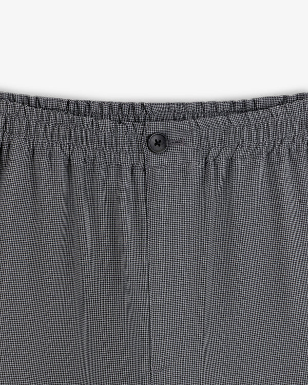 Close-up of Houndstooth Elasticated Waist Trouser with gray checks, stretchy waistband, and a single black button.