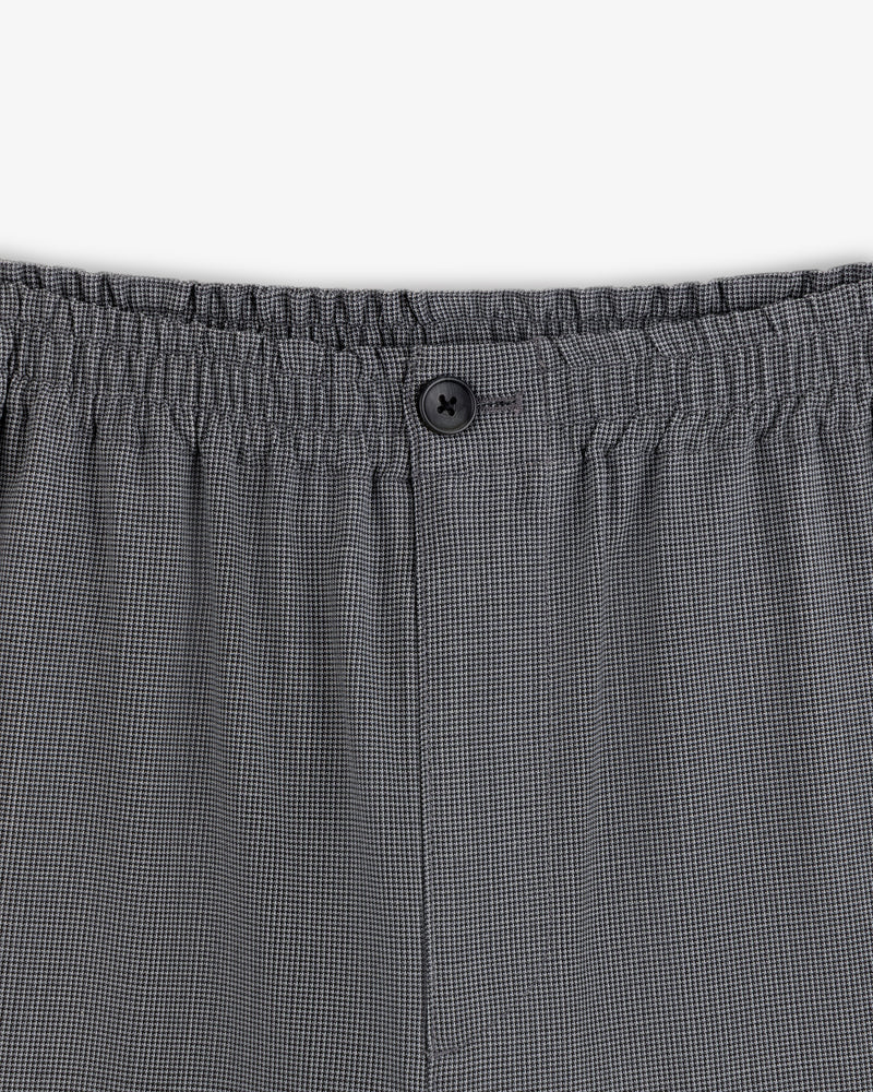 Close-up of Houndstooth Elasticated Waist Trouser with gray checks, stretchy waistband, and a single black button.