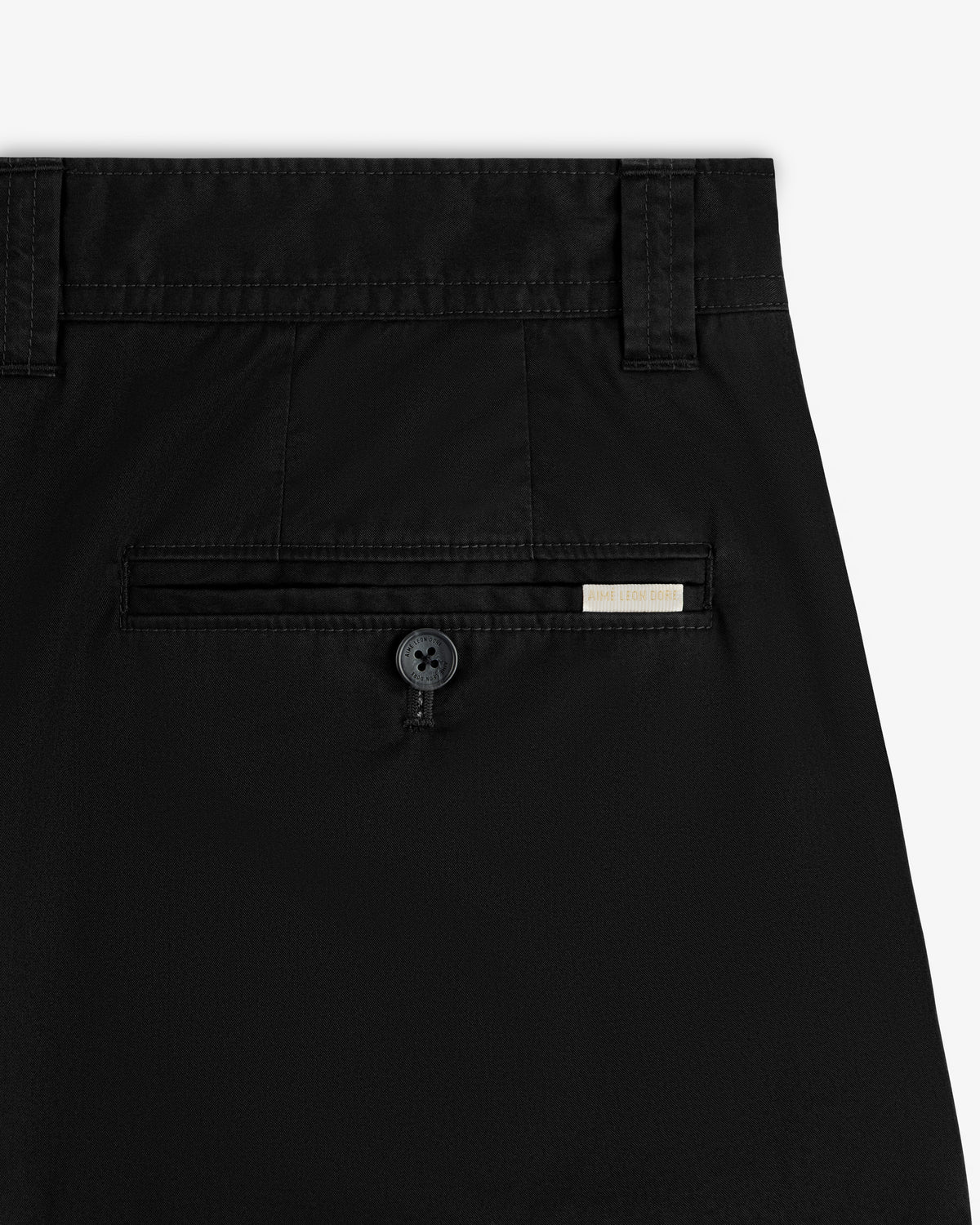 Close-up of Double Pleated Officer Pant’s back pocket with button and small rectangular label above the pocket.