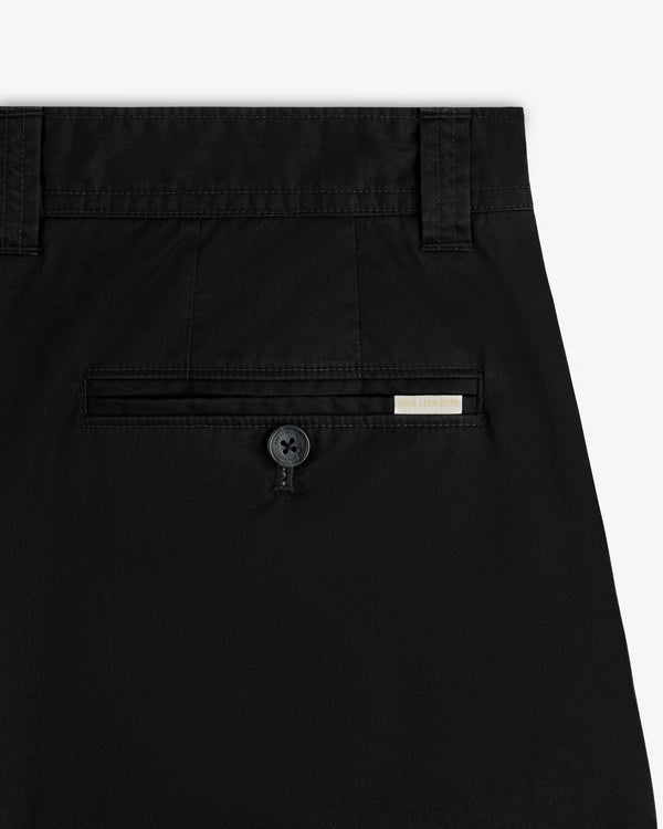 Close-up of Double Pleated Officer Pant’s back pocket with button and small rectangular label above the pocket.