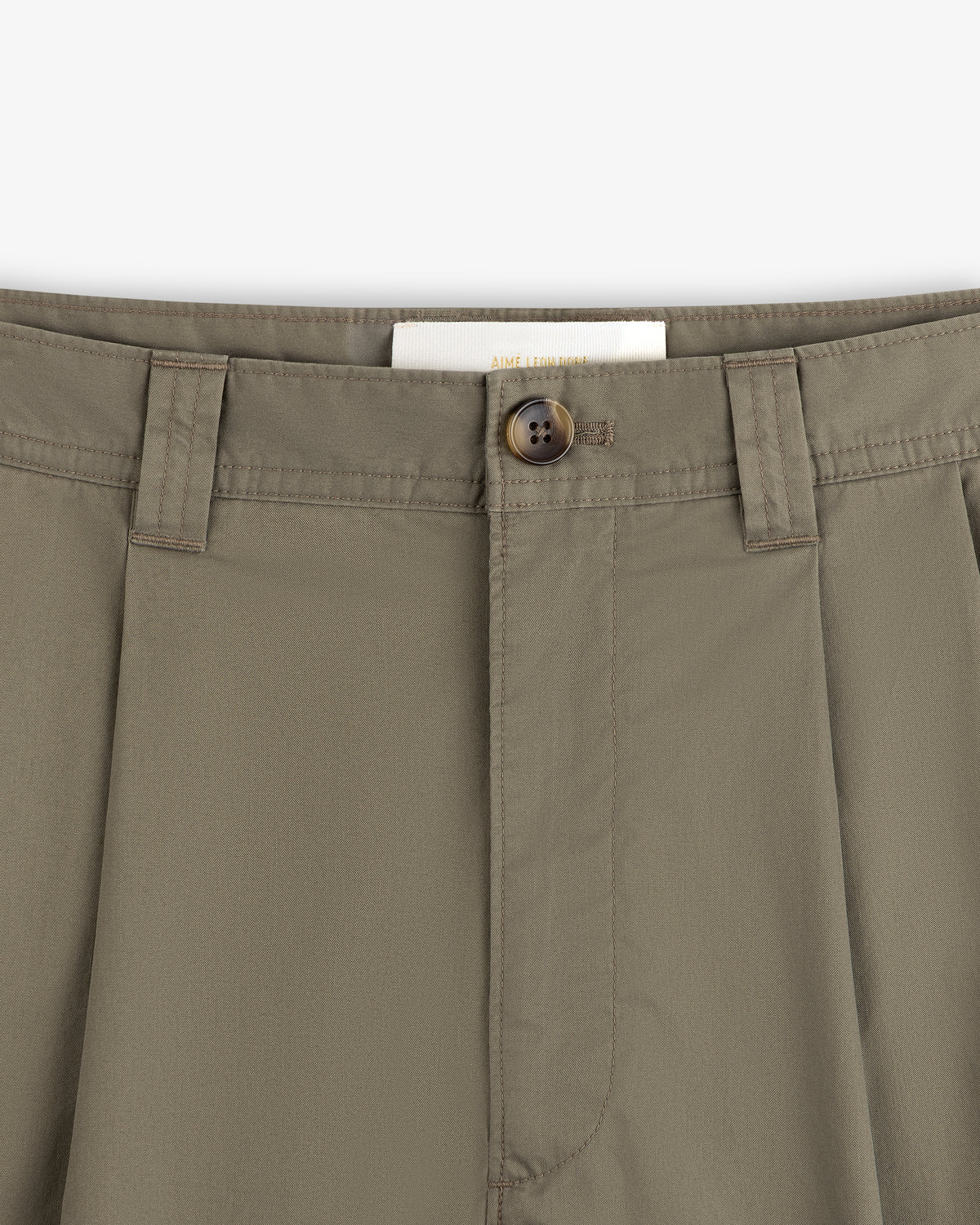 Close-up of Double Pleated Officer Pant waist with belt loops, brown button, and partially visible inside label.