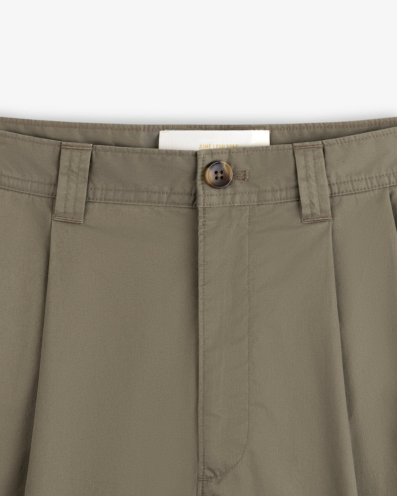 Close-up of Double Pleated Officer Pant waist with belt loops, brown button, and partially visible inside label.