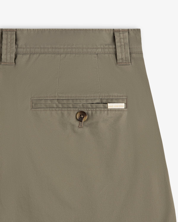 Close-up of Double Pleated Officer Pant’s back pocket with button closure and label above the pocket.
