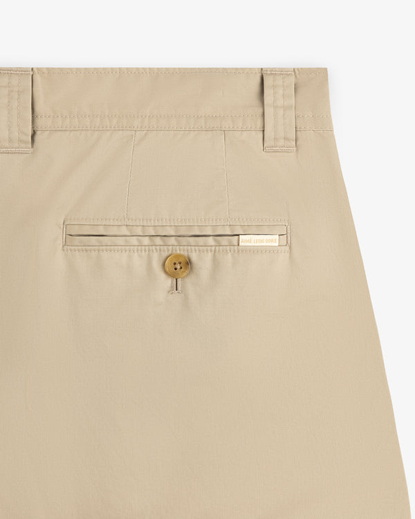 Close-up of Double Pleated Officer Pant’s back pocket with button closure, belt loops, and label above the pocket.