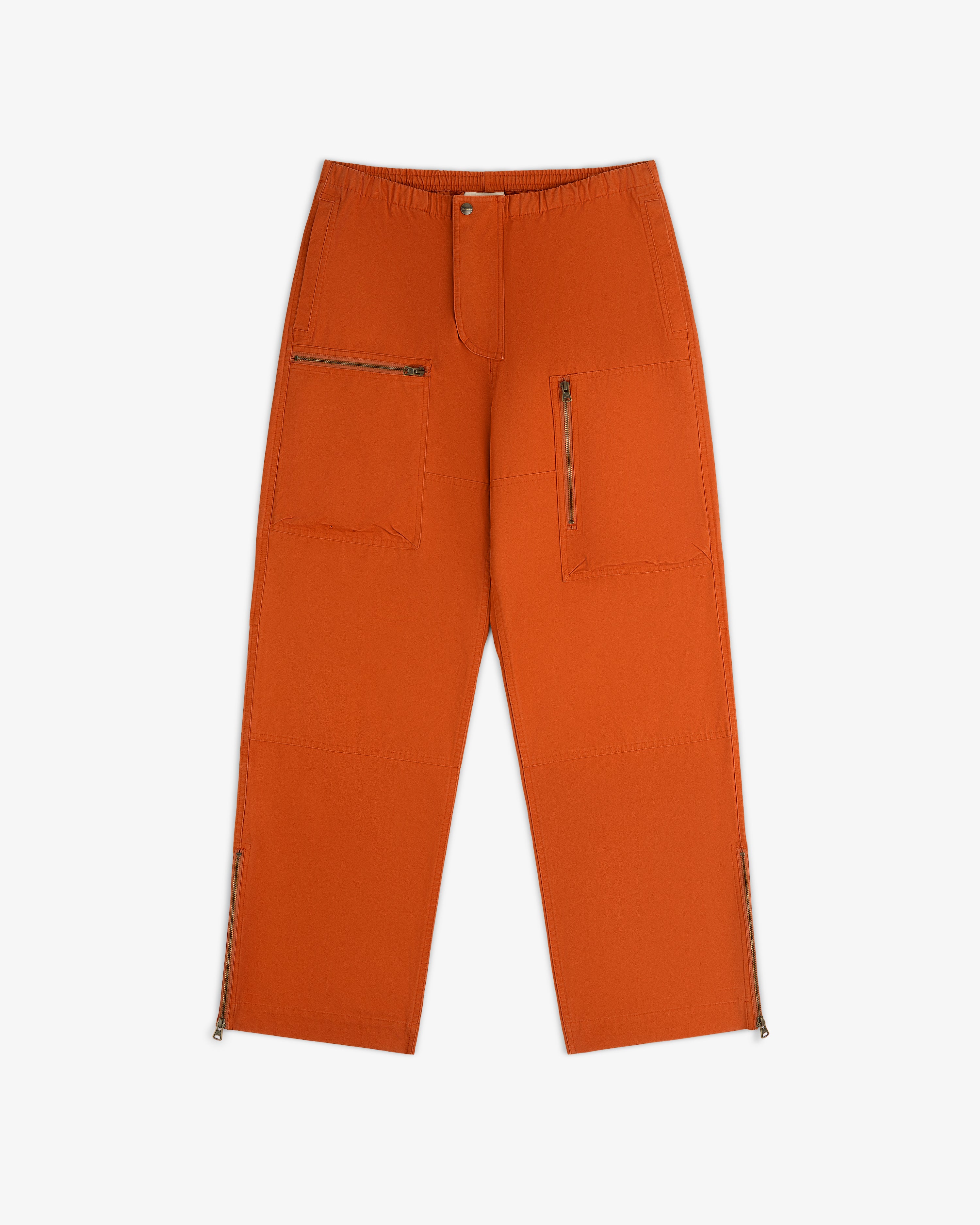 Garment Washed Aviator Pants in burnt orange with zippered cargo pockets and leg openings.