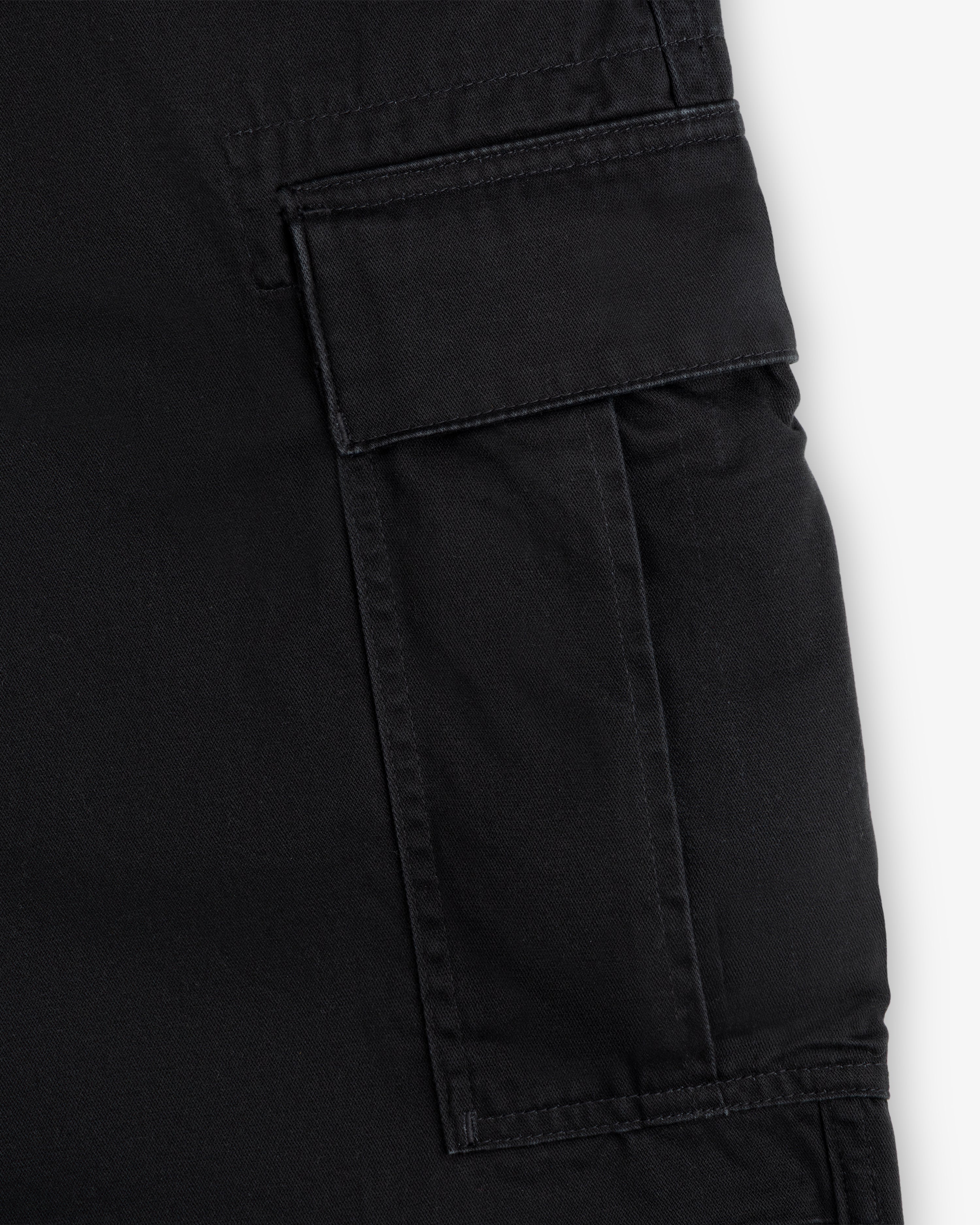 Close-up of a black cargo pocket with a flap and visible stitching on the Fatigue Pant.