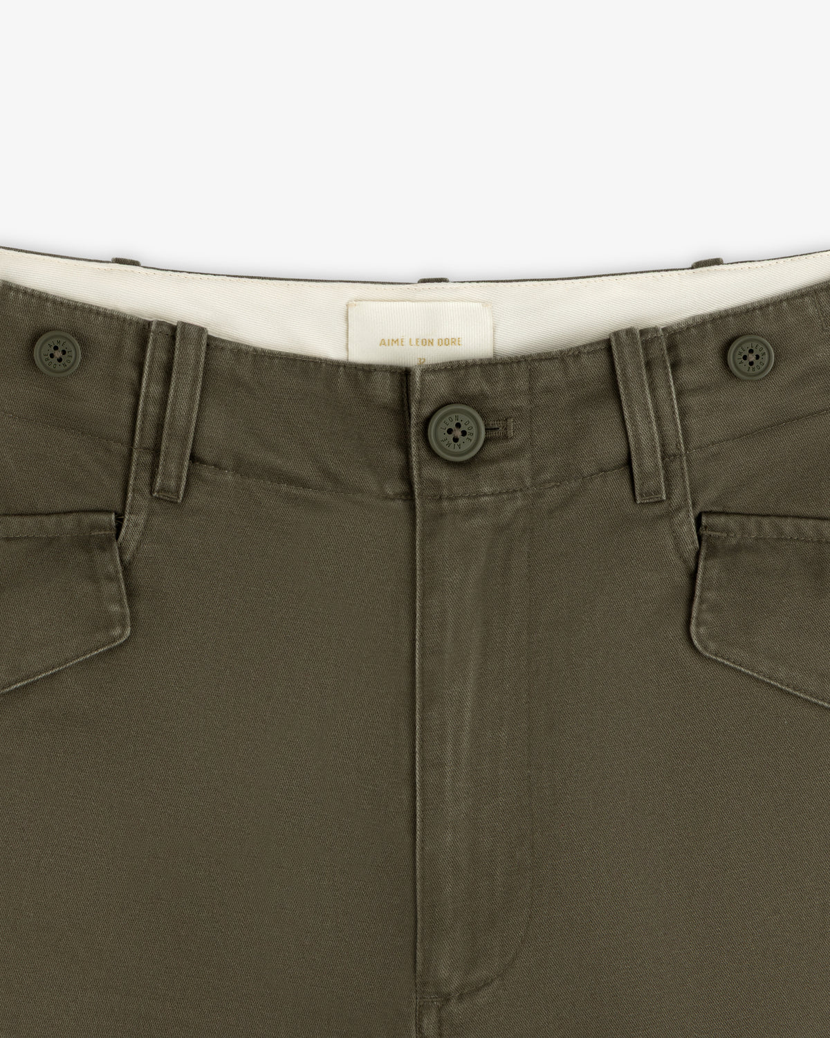 Close-up of Fatigue Pant in olive green with two buttons, belt loops, and white inner waistband.