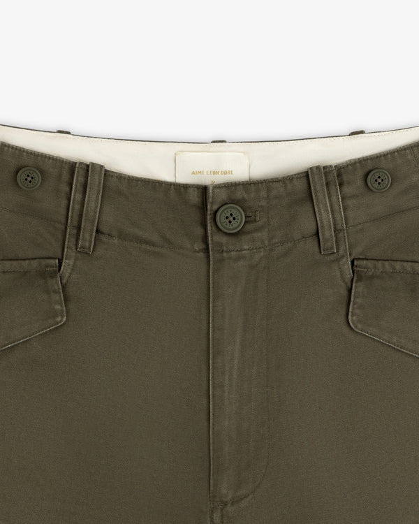 Close-up of Fatigue Pant in olive green with two buttons, belt loops, and white inner waistband.