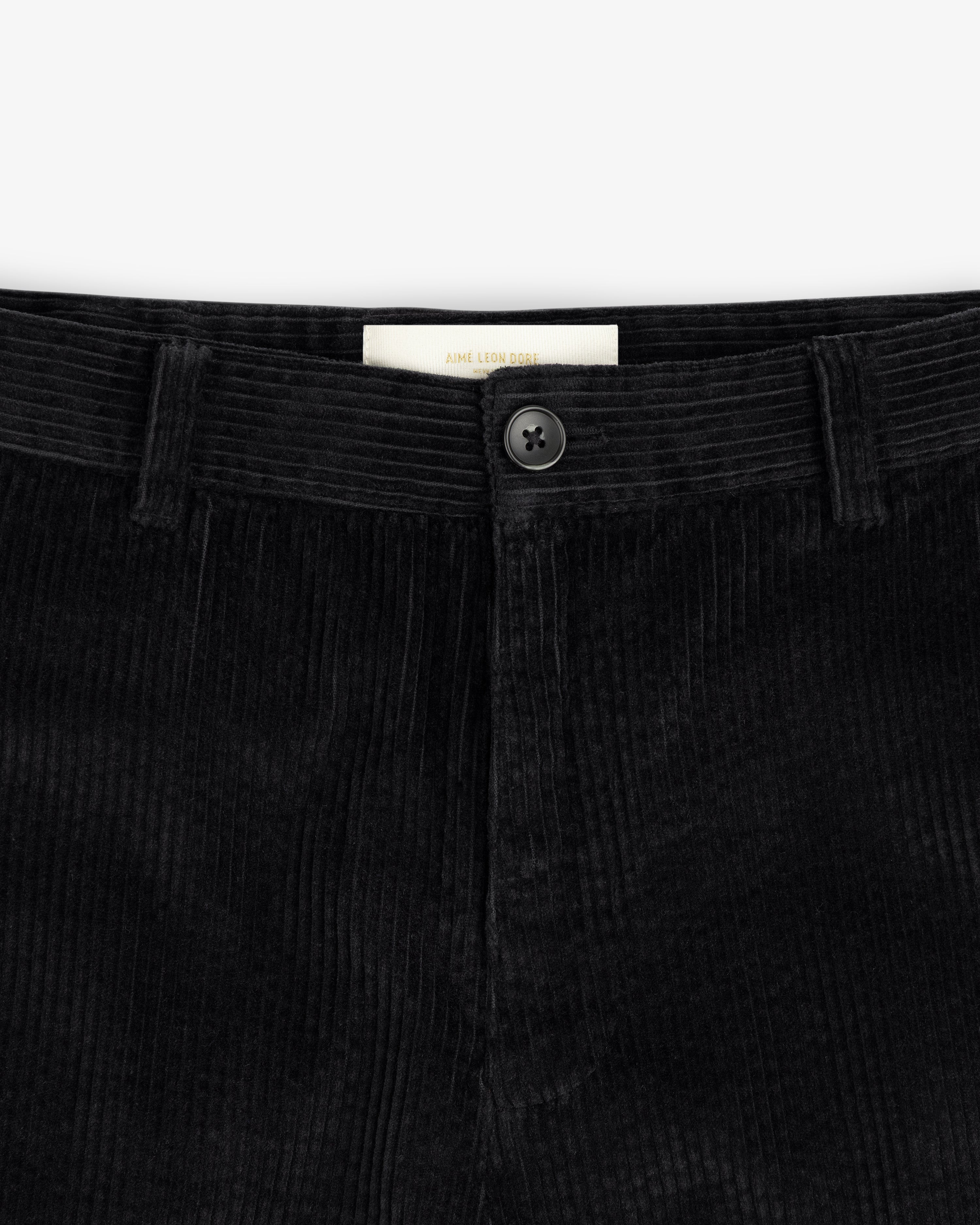 Black Corduroy Trouser with a button fly and a branded interior label.