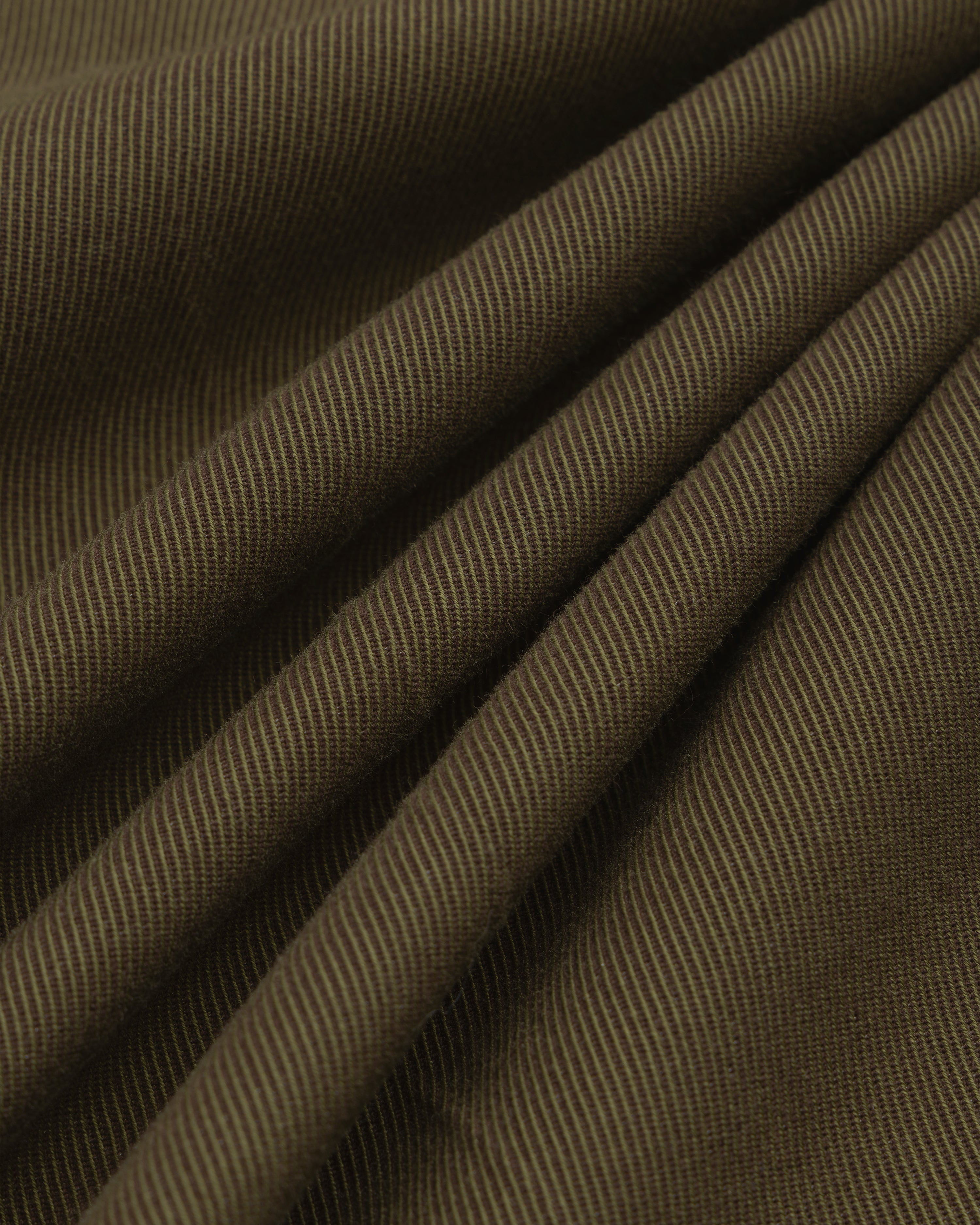 Close-up of olive green Wool Blend Suit Trouser fabric with a diagonal twill weave and soft folds.