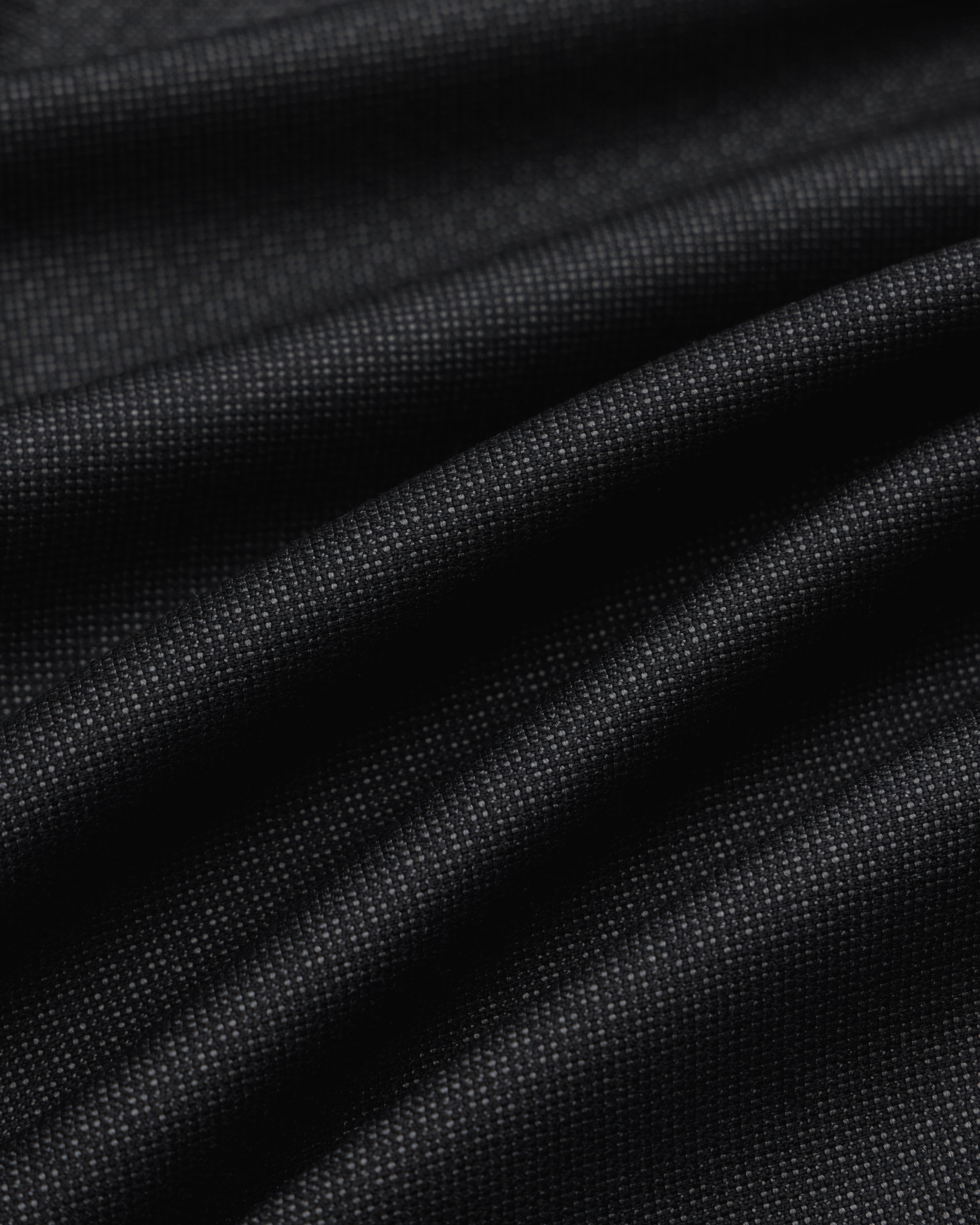 Close-up of black Double Pleated Wool Jacquard Suit Trouser fabric with a fine, textured weave and subtle pleats.