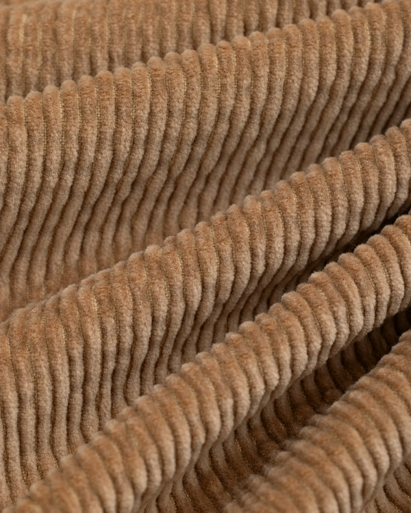 Close-up of tan corduroy fabric with vertical ridges on a Double Pleated Corduroy Trouser.
