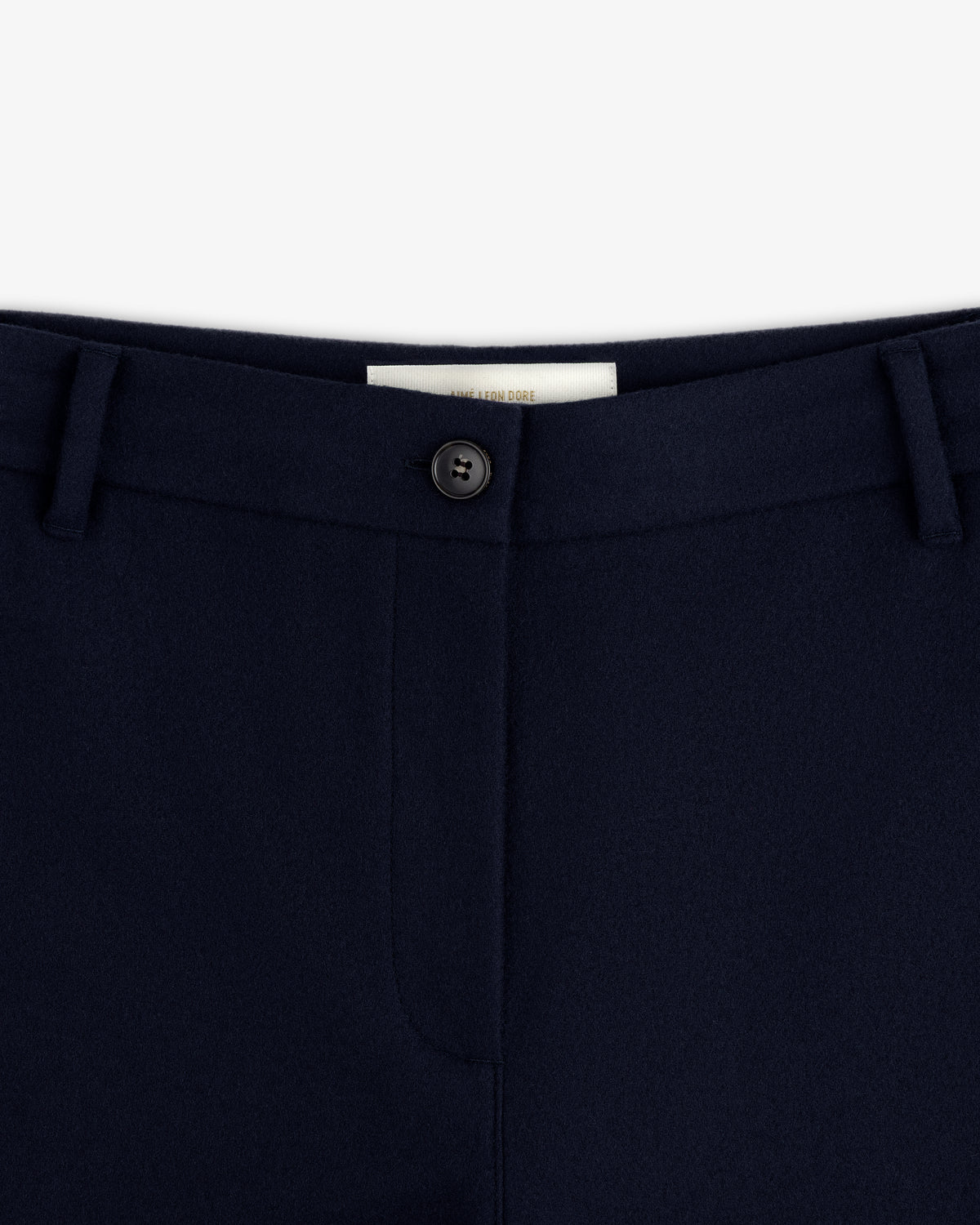 Close-up of the navy blue Mani Embroidered Wool Pant waistband with a single button closure and belt loops.