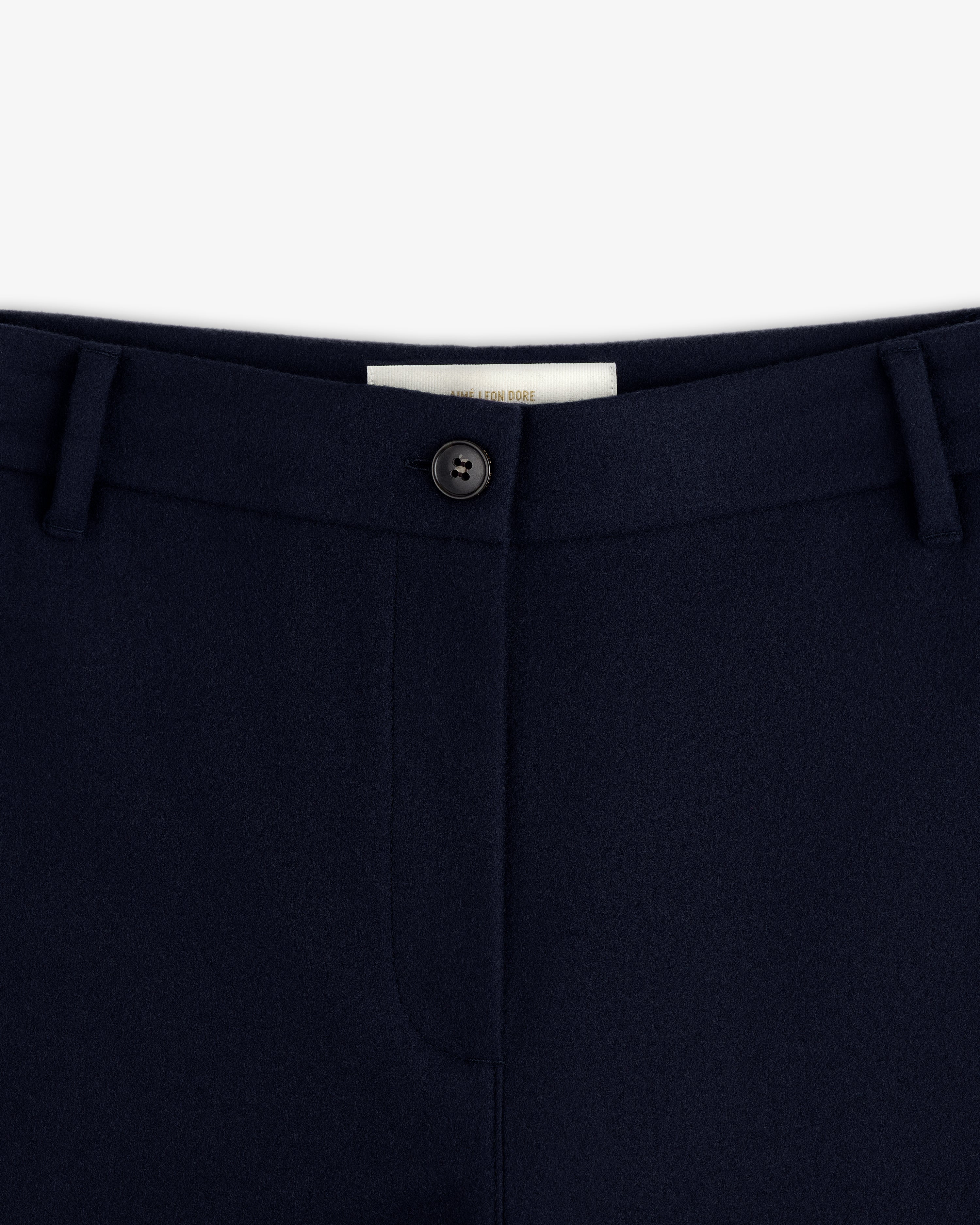 Close-up of the navy blue Mani Embroidered Wool Pant waistband with a single button closure and belt loops.
