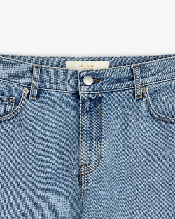 Close-up of the metal button, fly, and waistband of light blue ALD Relaxed Fit Denim jeans.