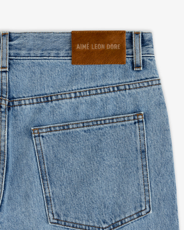 Back pocket and waistband of light blue ALD Relaxed Fit Denim jeans with a brown leather logo patch.