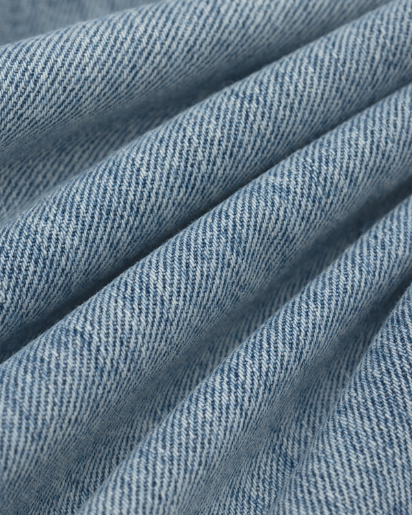 Close-up of blue ALD Relaxed Fit Denim fabric with diagonal folds.