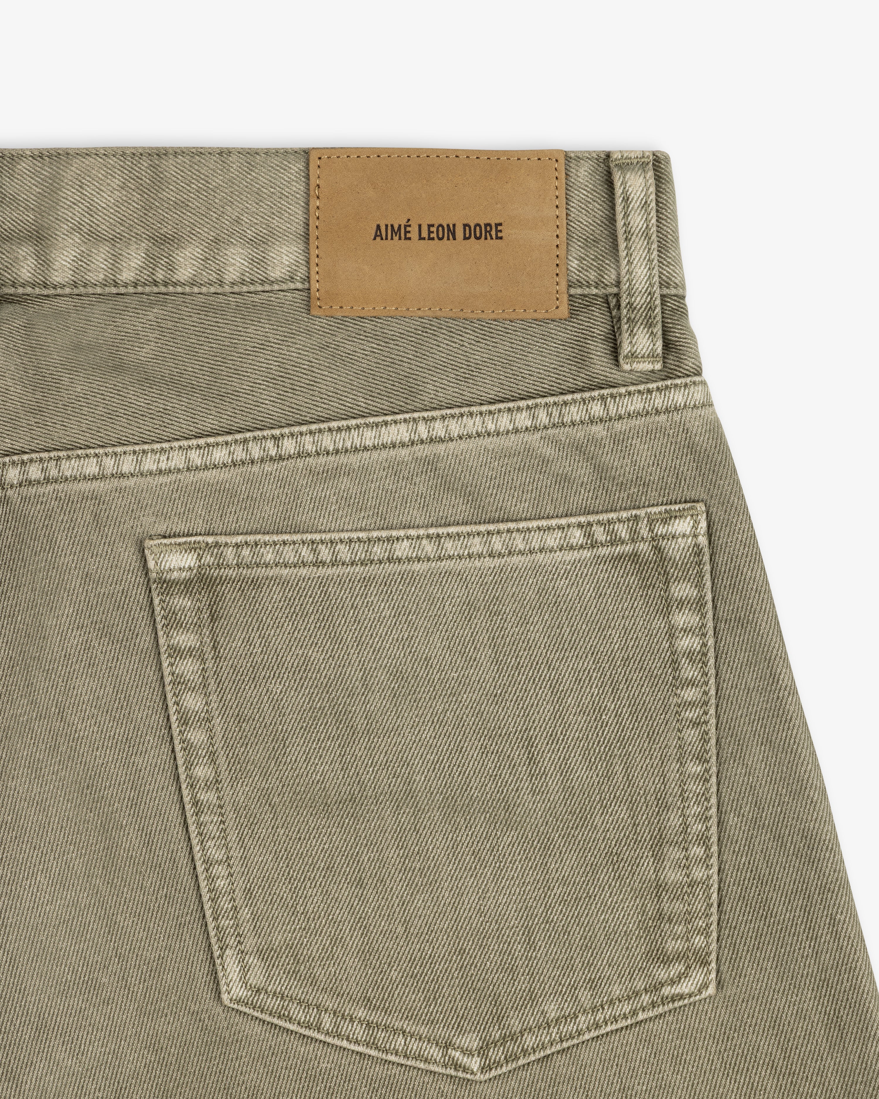 Olive-colored Flocked Straight Fit Denim jeans with a tan leather brand patch on the back waistband.