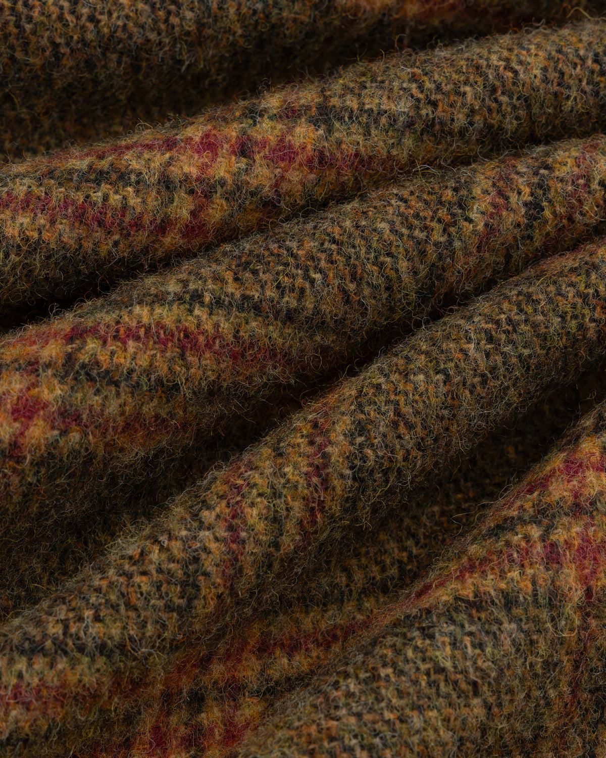 Close-up of thick, textured wool Plaid Tweed Suit Trouser fabric with a multicolored plaid pattern.
