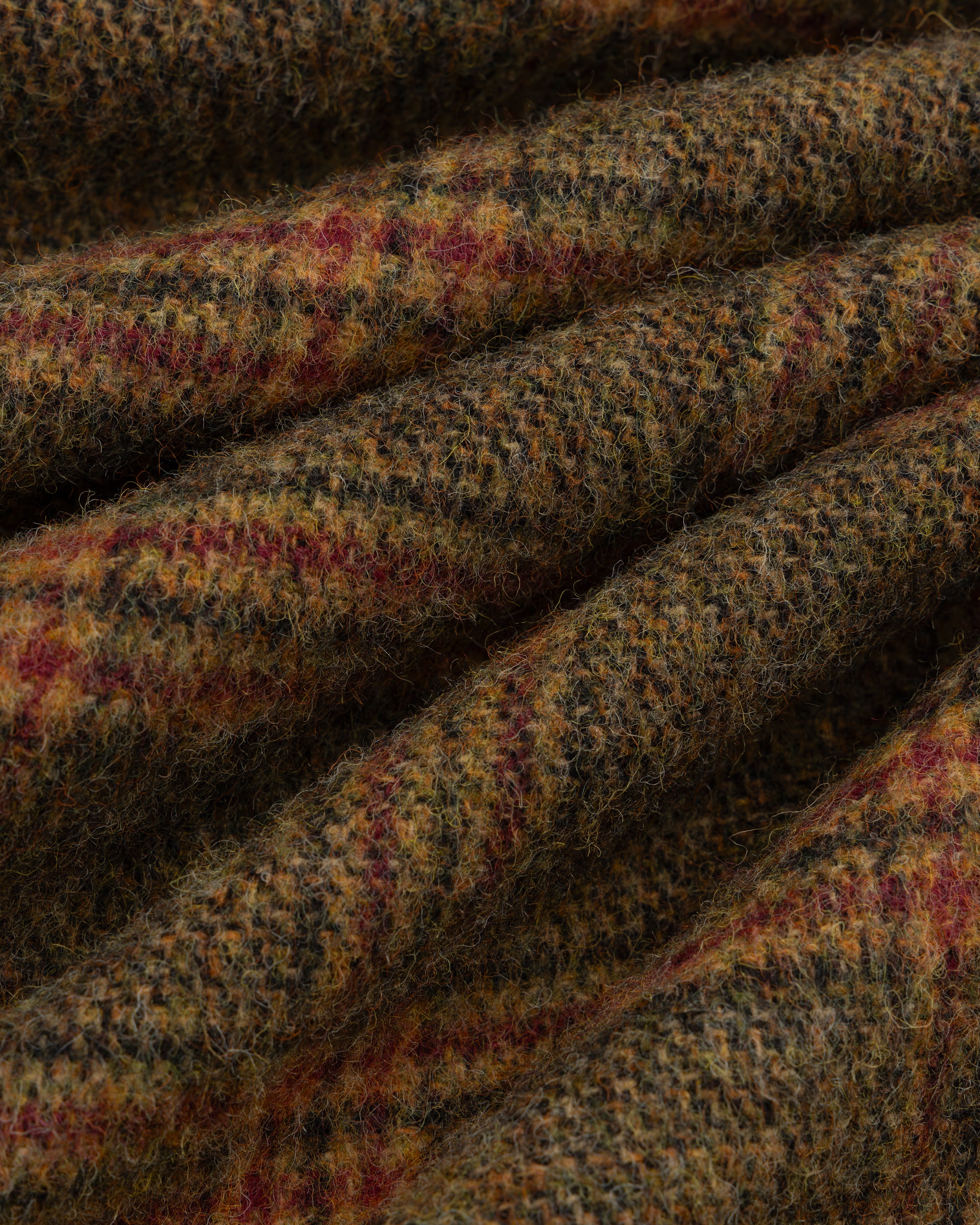 Close-up of thick, textured wool Plaid Tweed Suit Trouser fabric with a multicolored plaid pattern.